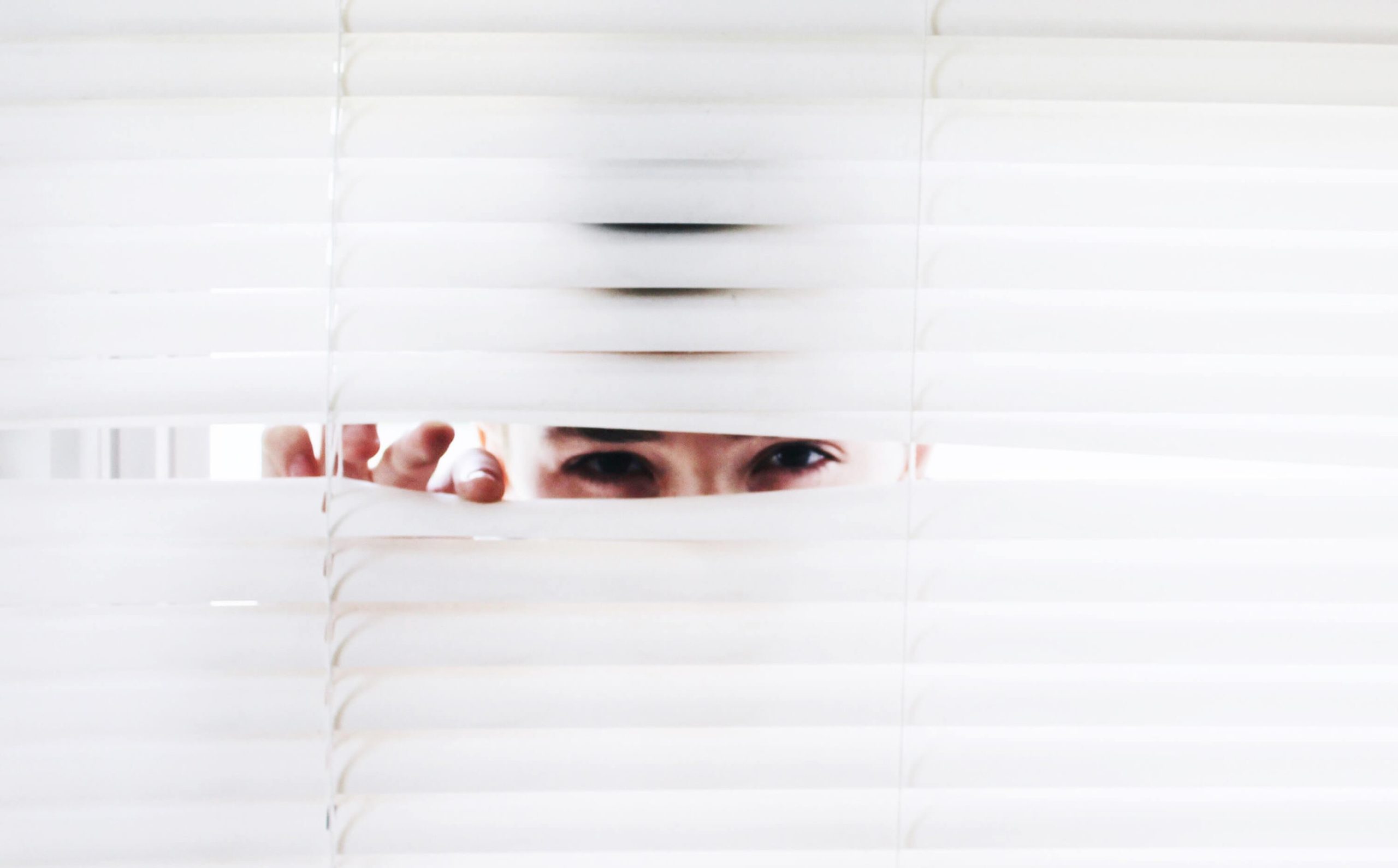 A person pulling the blind fold to take a peak.