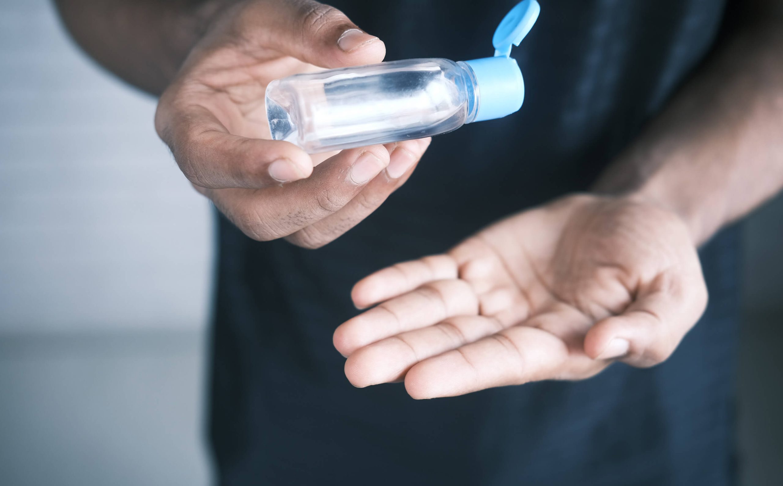 A man about to pour a few drops of hand sanitizer on his palm.