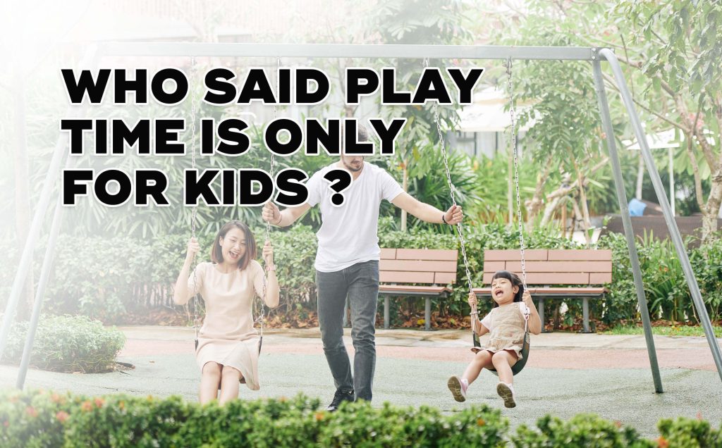 A woman and a child playing with the swing while a man pushes them.