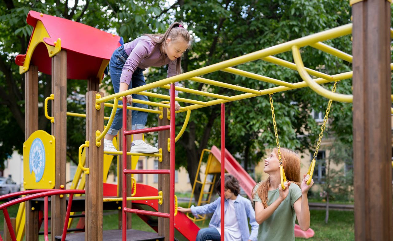 A group of children playing at the outdoor gym, climbing on the monkey bars.
