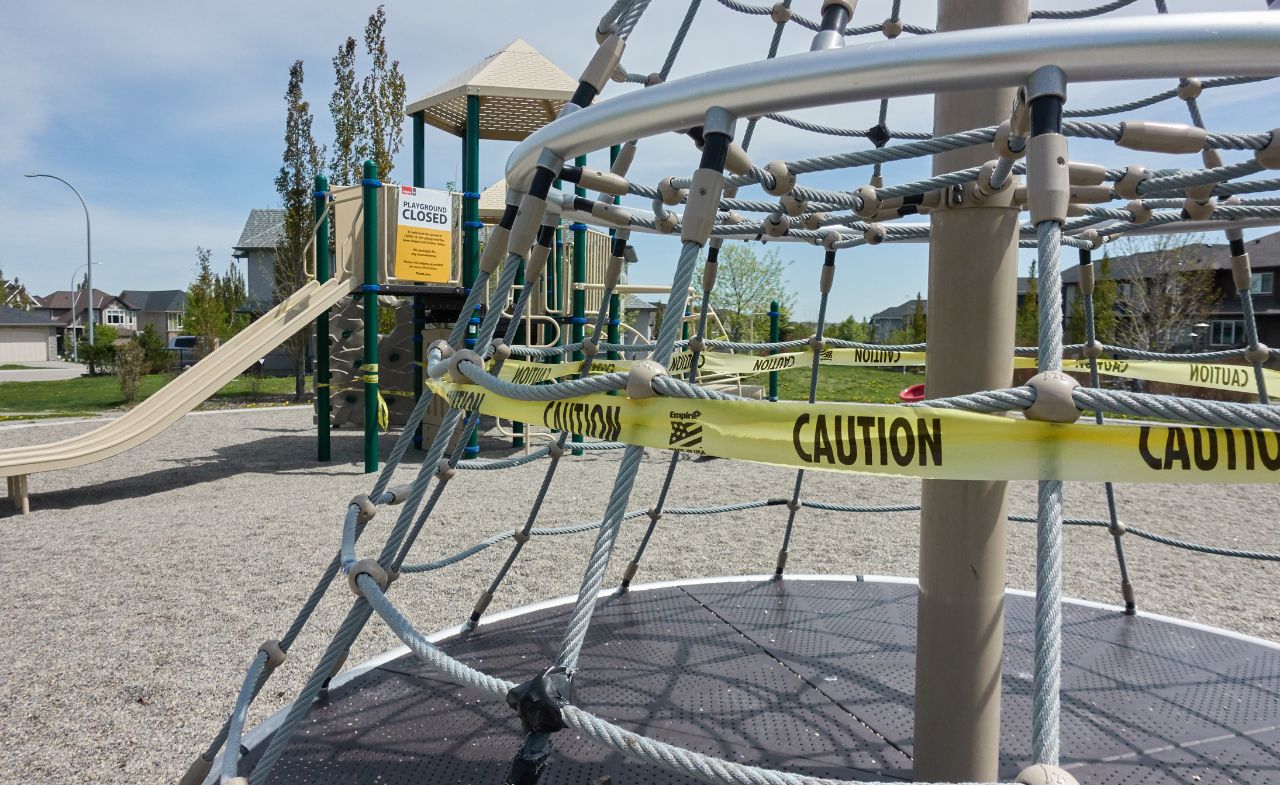 A playground that is closed for use, with notice surrounding it.