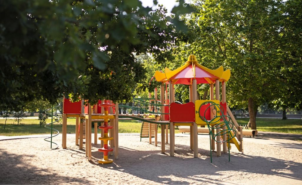 A complete playground set at the community’s park with kids playing.